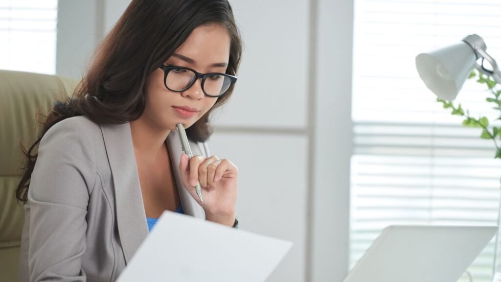 Profissional estudando curso de inteligência emocional e lendo livros para desenvolver competências emocionais no trabalho.