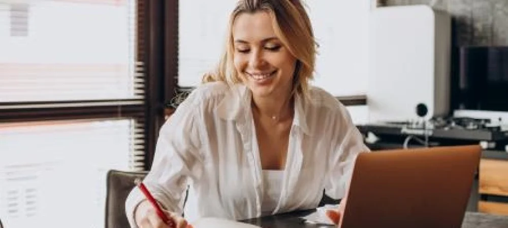 IMAGEM-TRIO-mulher-trabalhando-em-casa-no-laptop-escrevendo-em-uma-agenda