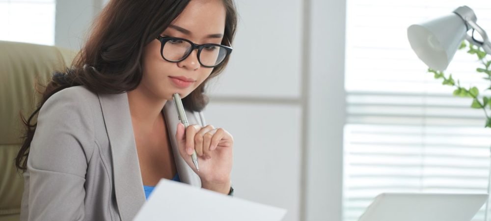 Profissional estudando curso de inteligência emocional e lendo livros para desenvolver competências emocionais no trabalho.