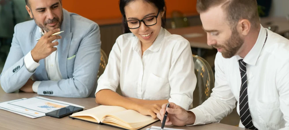 three-positive-business-people-working-with-documents-desk-compressed-2